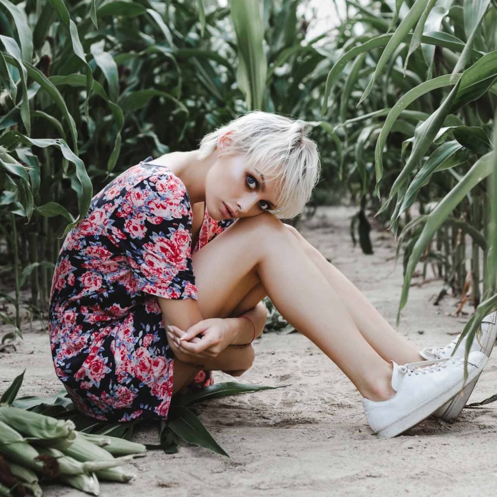 girl-between-green-leaves-in-a-corn-field-PD8U4Z5.jpg
